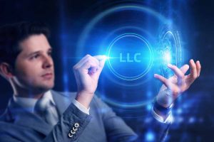 Business man working on the tablet of the future, select on the virtual display: LLC.