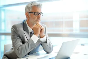 Concerned business owner in suit looking at laptop discovering Georgia LLC administrative dissolution status