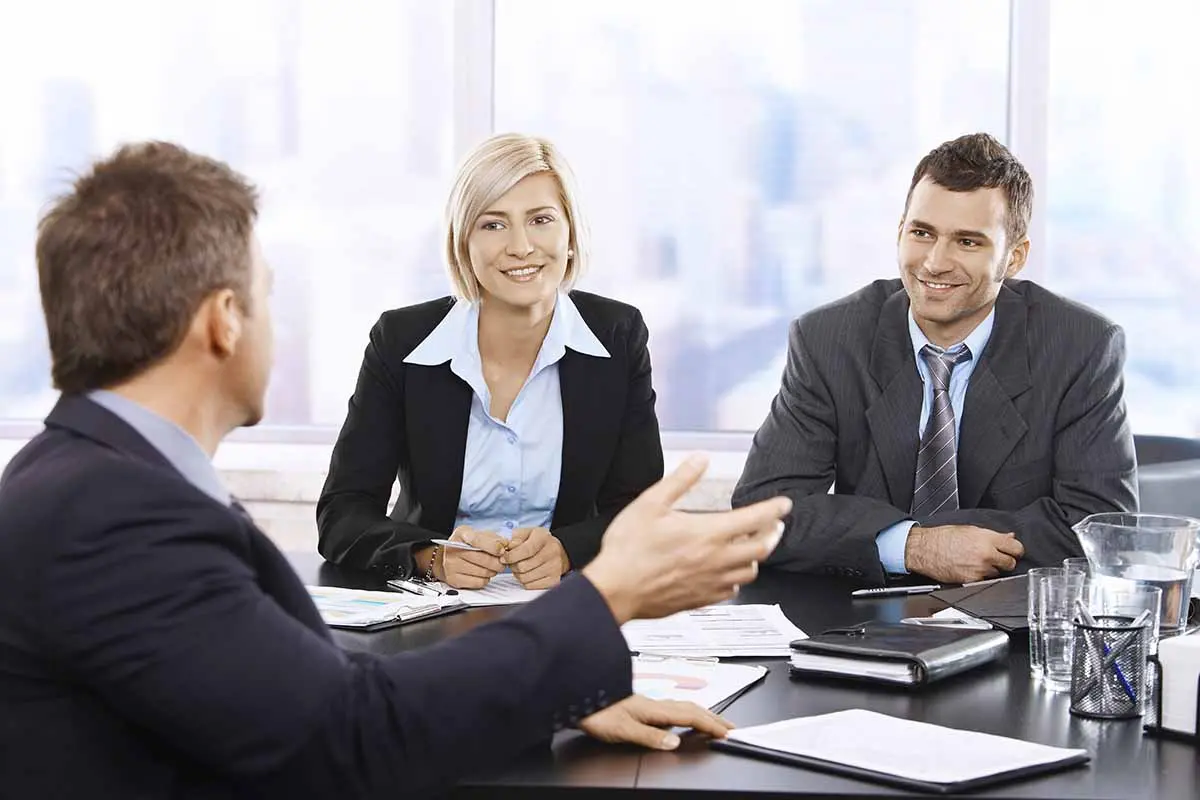 Business owners meeting at a desk to discuss transferring LLC ownership