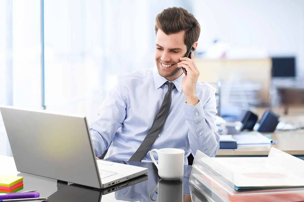 Business owner calculating the cost to start an LLC using a laptop and business documents