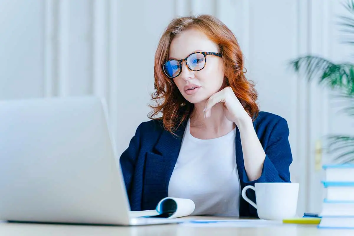 Business owner reviewing an LLC operating agreement on a laptop before creating an operating agreement.