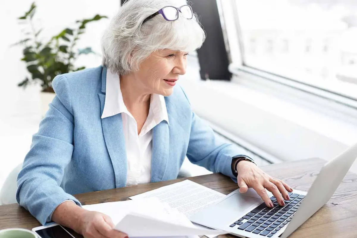Business owner reviewing LLC membership documents and business records on a laptop